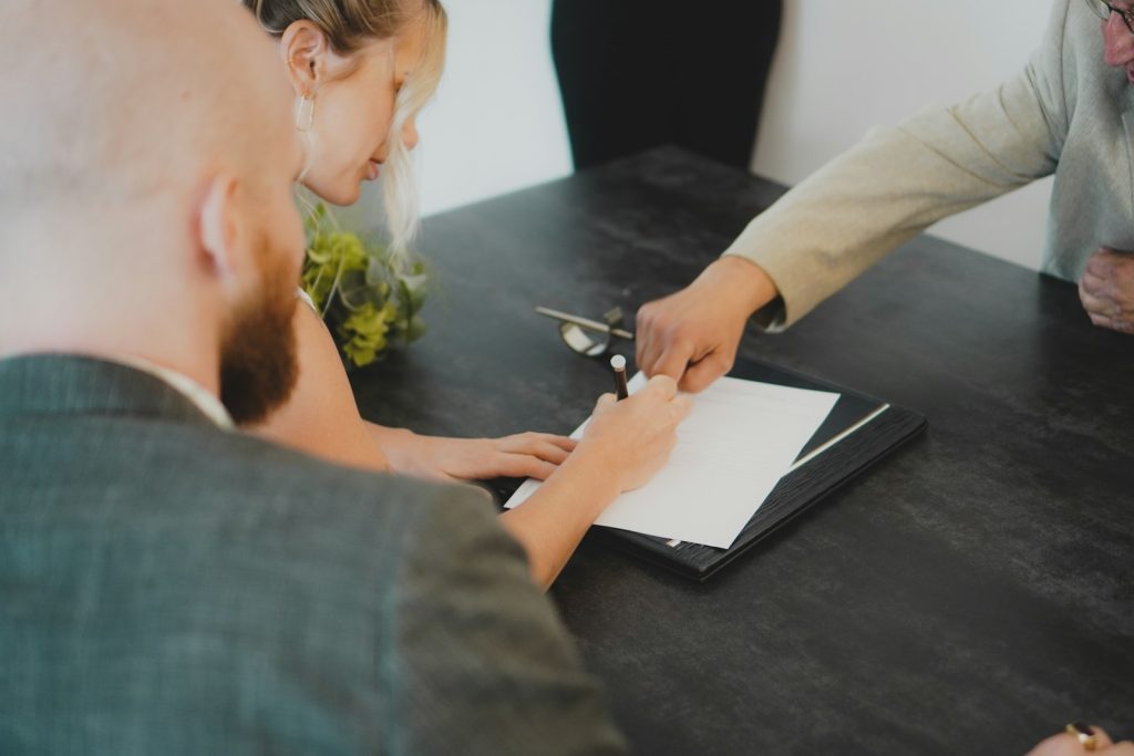 Couple signing property papers together, representing joint ownership of a Dubai home for a Golden Visa