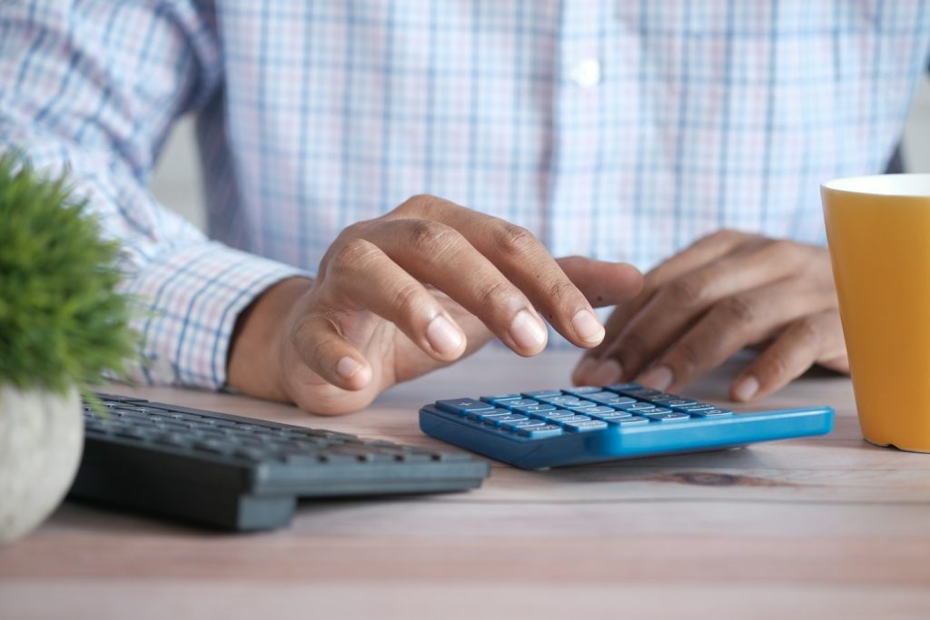 Person using a calculator to budget the Dubai property visa cost and government fees