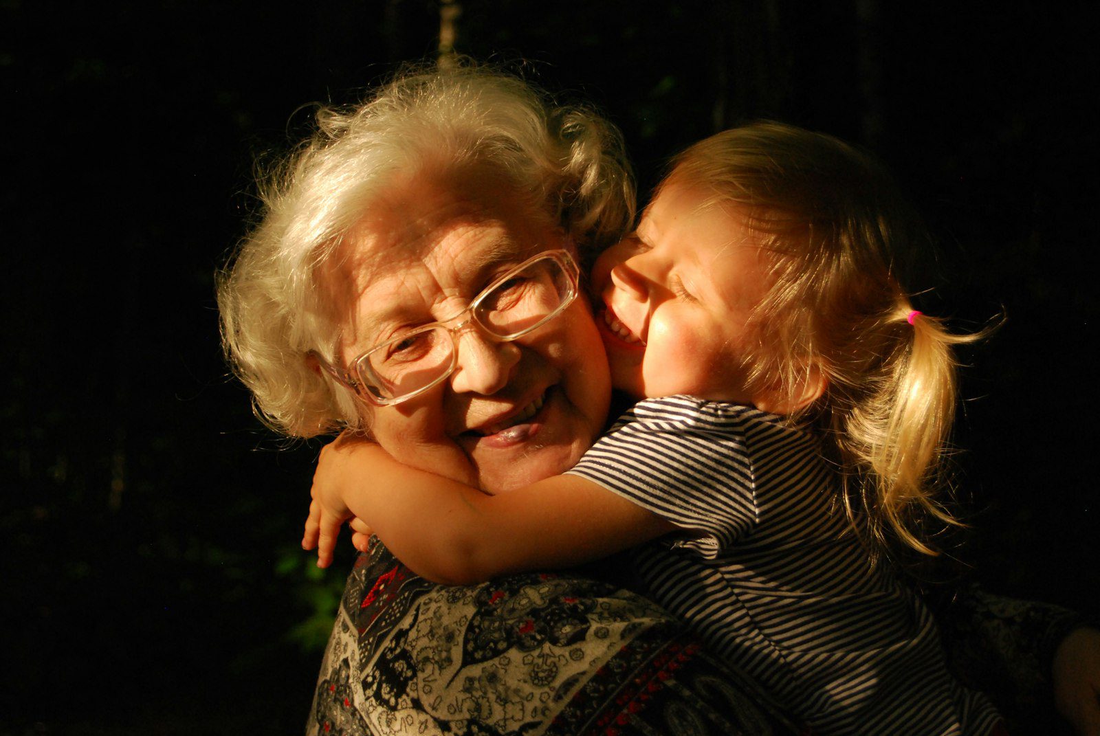 Grandmother hugging her grandchild, showing parents sponsored on a property owner's residence visa